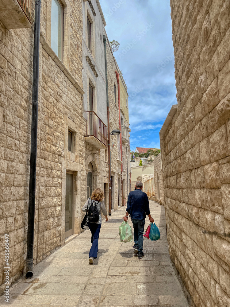 A couple walks through the streets of the old town of Molfetta, Puglia, Italy