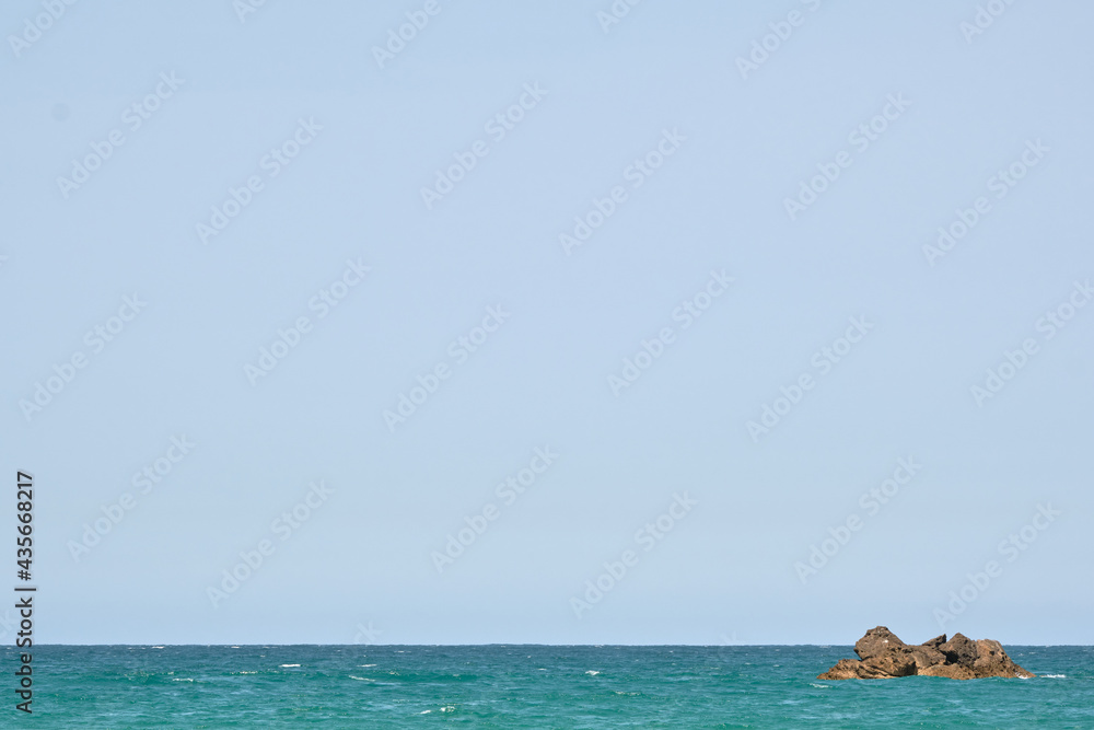 Coastal landscape of a rocks in the middle of a blue sea. With space to put text Coastal landscape of a rocks in the middle of a blue sea. With space to put text