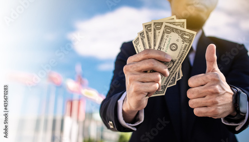 Businessman holding dollar money business investment concept