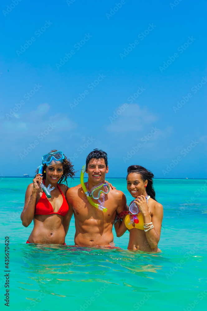 Girls and guy at the beach, in the water with goggles, snorkling, interracial, black Girls and guy at the beach, in the water with goggles, snorkling, interracial, black