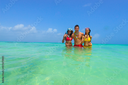 Girls and guy at the beach, in the water with goggles, snorkling, interracial, black