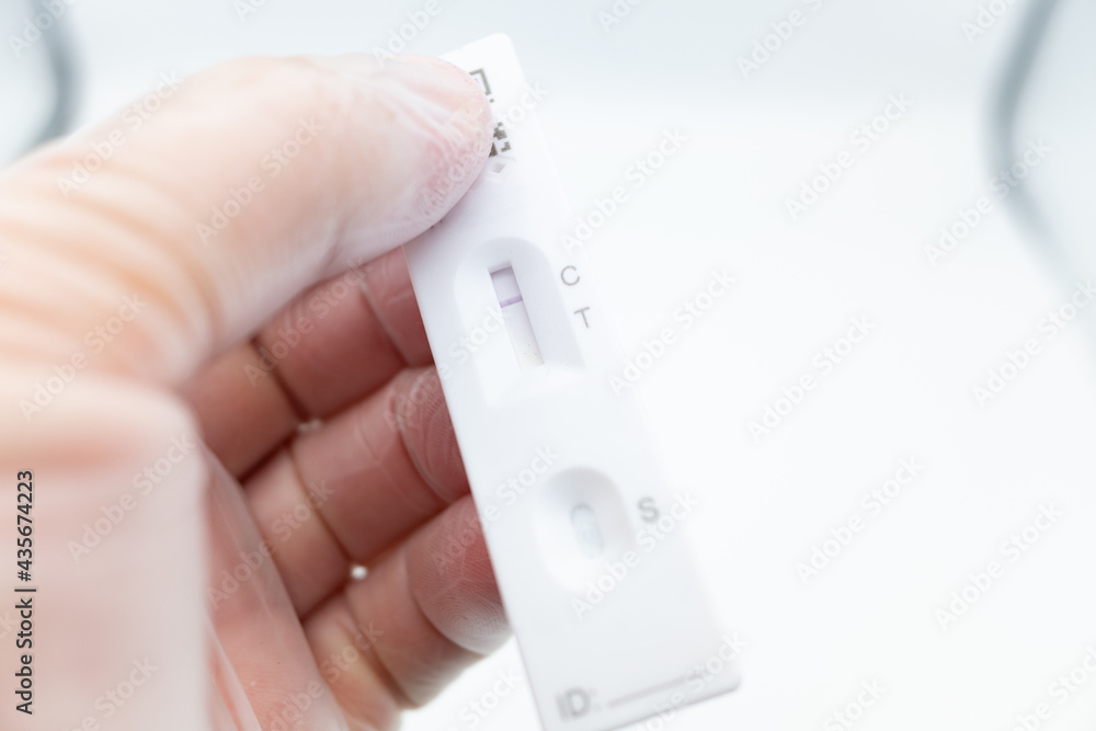 close up of a hand holding a lateral flow test close up of a hand holding a lateral flow test