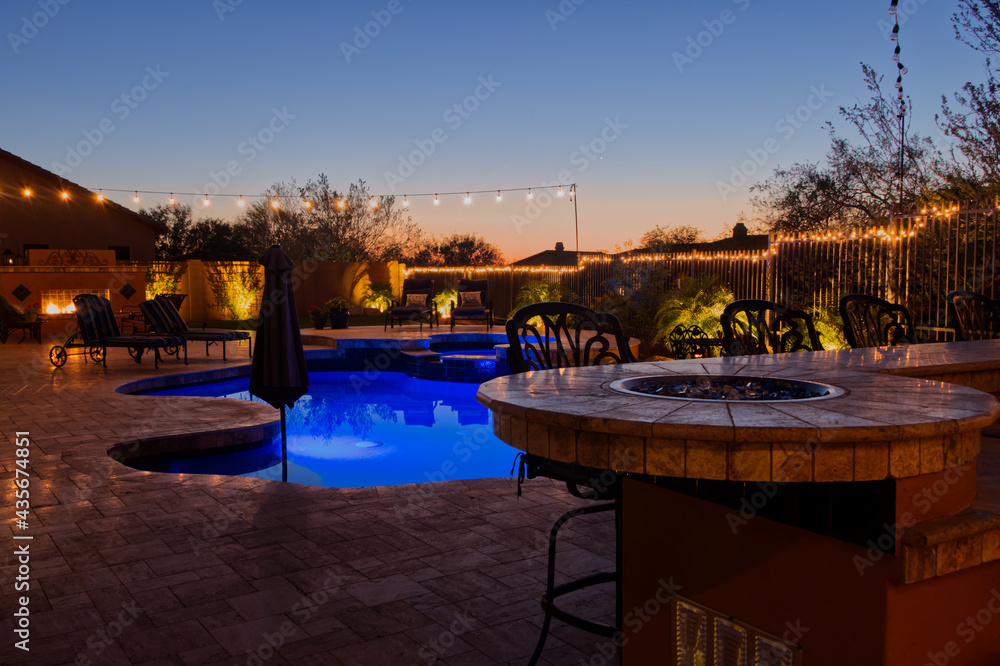 A high definition view of a desert landscaped backyard in Mesa Arizona, with a pool spa, outdoor fireplace and Kitchen.