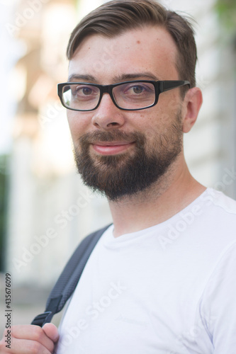 Portrait of a young smart man wearing glasses and a white t-shirt © Елена Бабанова