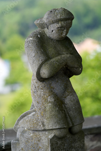 Stone sculpture of praying and kneeling person at fountain at cemetery. Photo taken May 25th  2021  Zurich  Switzerland.