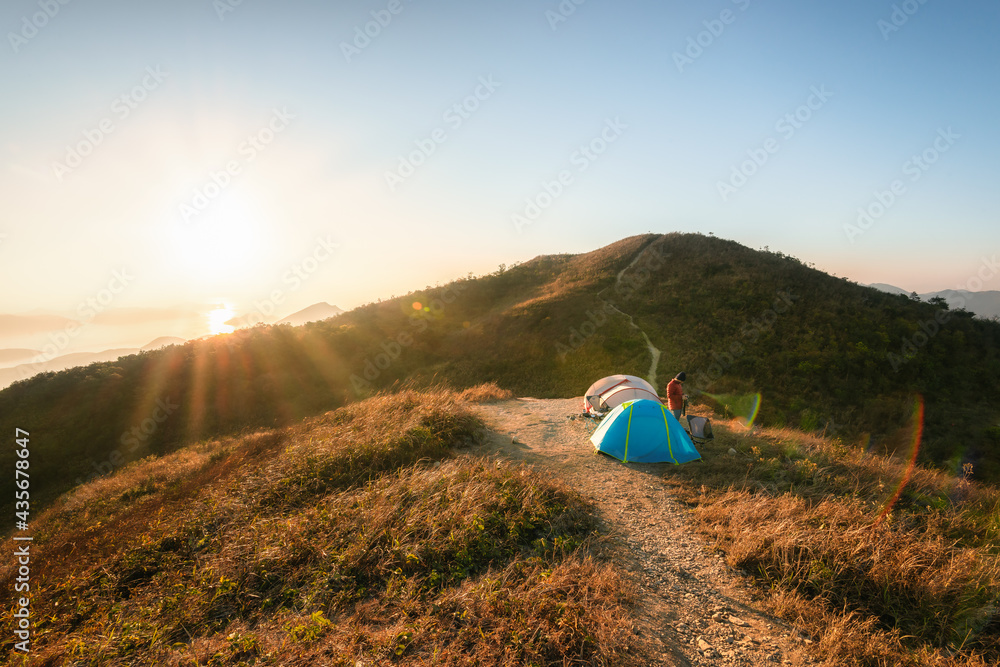 Man traveler Taking photo on top of mountains near of tent camping gear, Hiking at Kowloon Peak ( Fei Ngo Shan ) Hong Kong, People living healthy active lifestyle outdoors