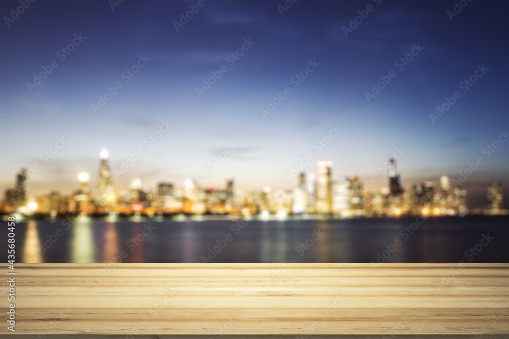 Blank wooden tabletop with beautiful blurry skyline at night on background, mockup
