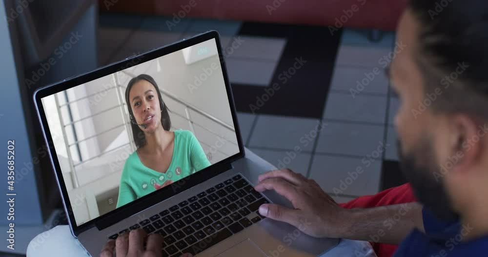 Middle eastern man having a video call with female colleague on laptop Middle eastern man having a video call with female colleague on laptop
