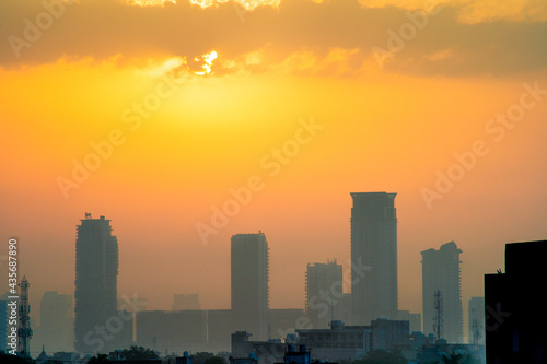 cloudy dusk dawn shot with the sun hidden and fog obscured sky scrapers multi story buildings of cityscape of gurgaon  mumbai  bangalore during the monsoons in India