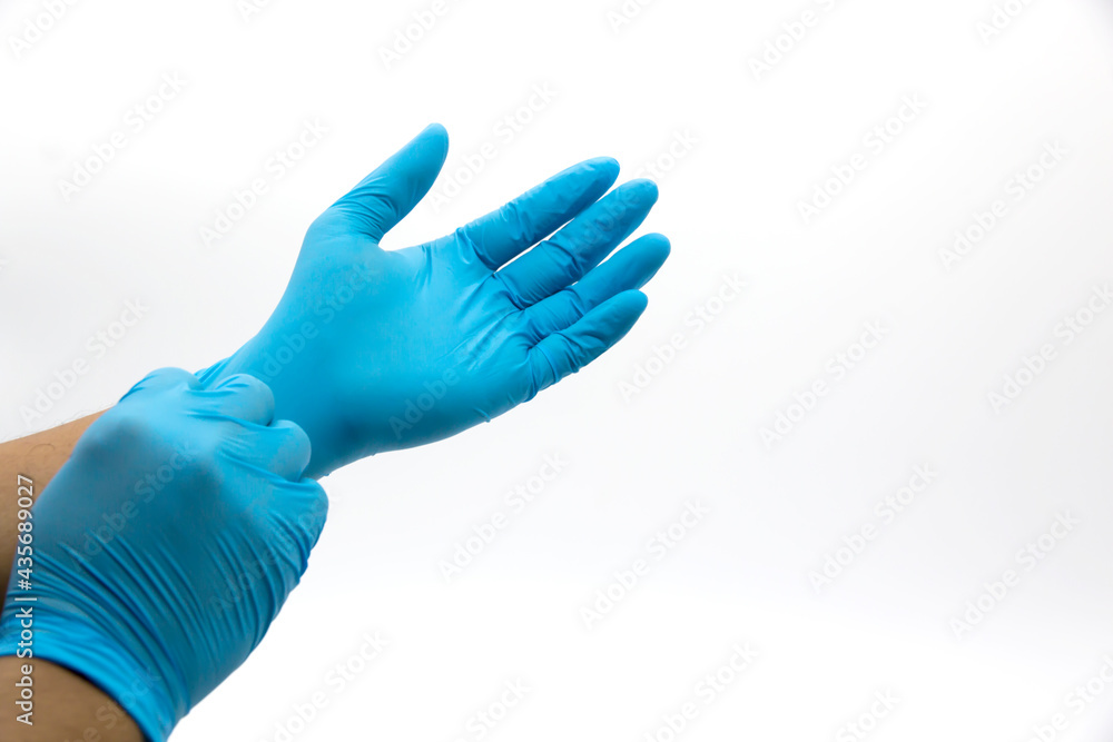 The doctor wore separate blue gloves on a white background.