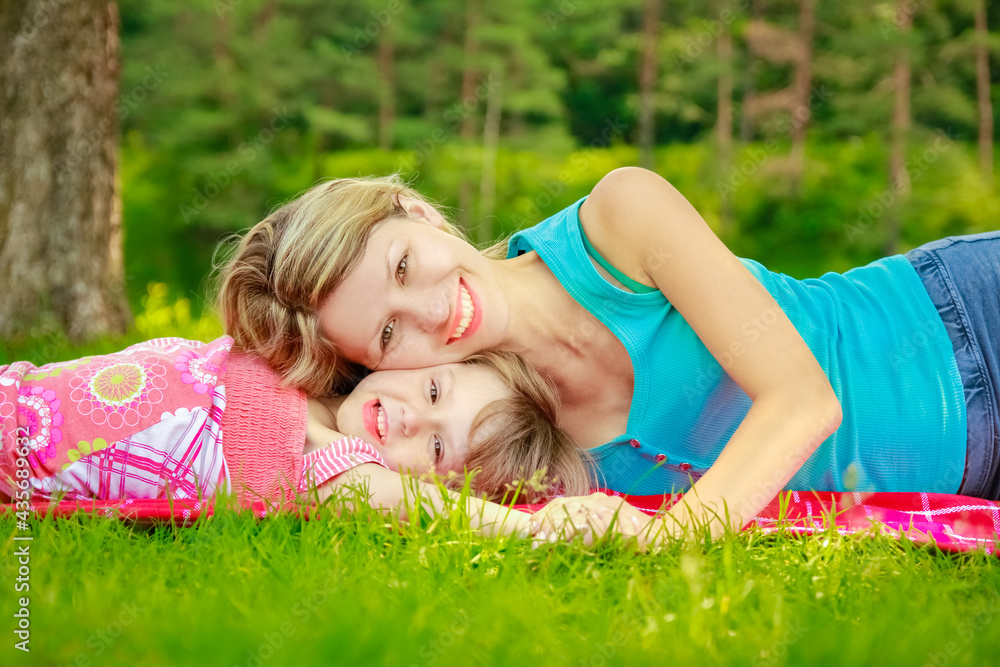 happy mother with baby in nature lying on the grass in the park happy mother with baby in nature lying on the grass in the park