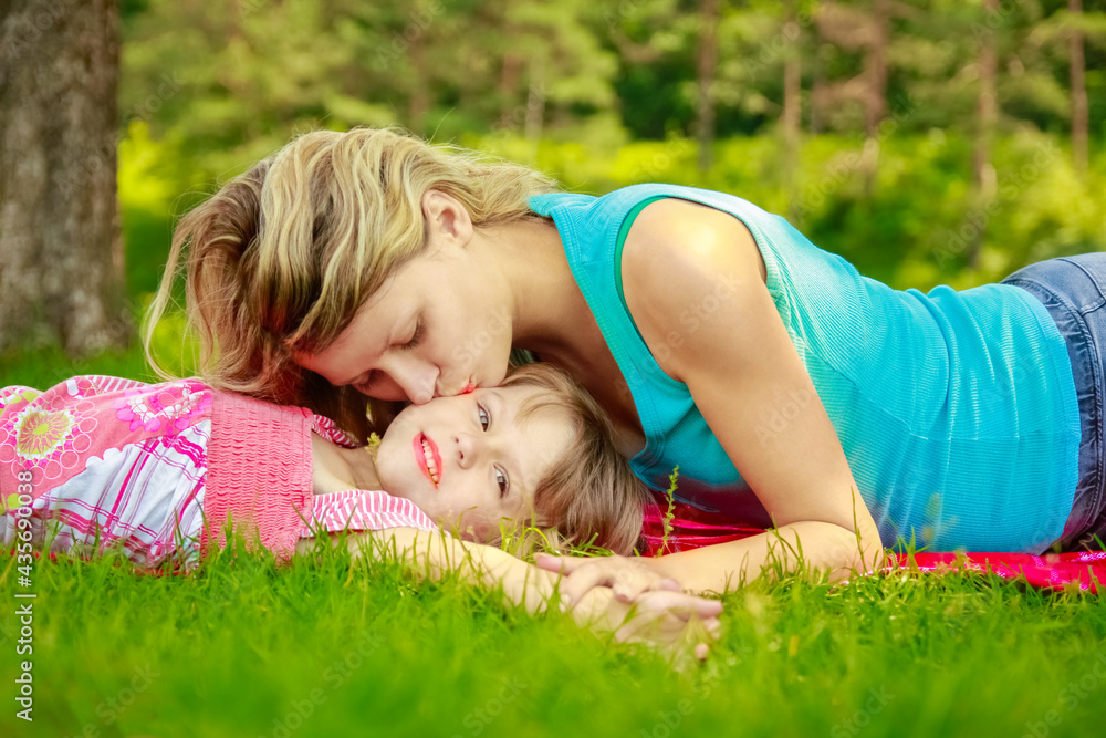 happy mother with baby in nature lying on the grass in the park happy mother with baby in nature lying on the grass in the park