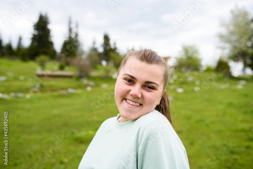 Portrait of a fat woman at the top of a mountain. High quality photo