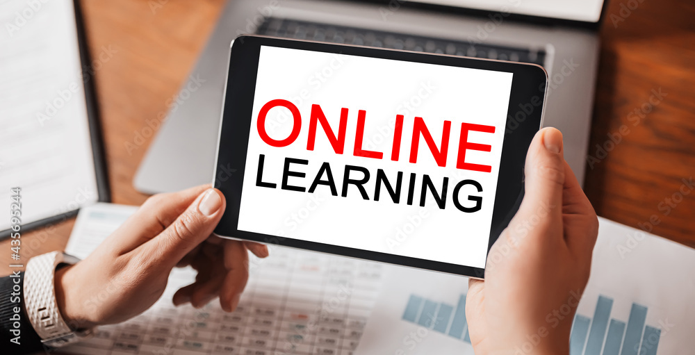 Man hands holding tablet with text online learning at workplace. Businessman working at desk with documents. study and education concept Man hands holding tablet with text online learning at workplace. Businessman working at desk with documents. study and education concept