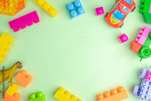 Kid toys laid out in the frame over mint green background.