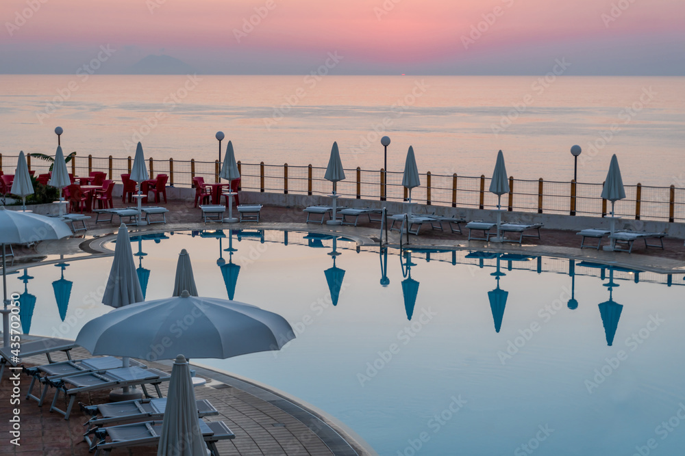 Tropea, Italy, August 2020: Beautiful swimming pool at sunset in a luxury resort, Trope as a popular tourist destination in Calabria, Italy.