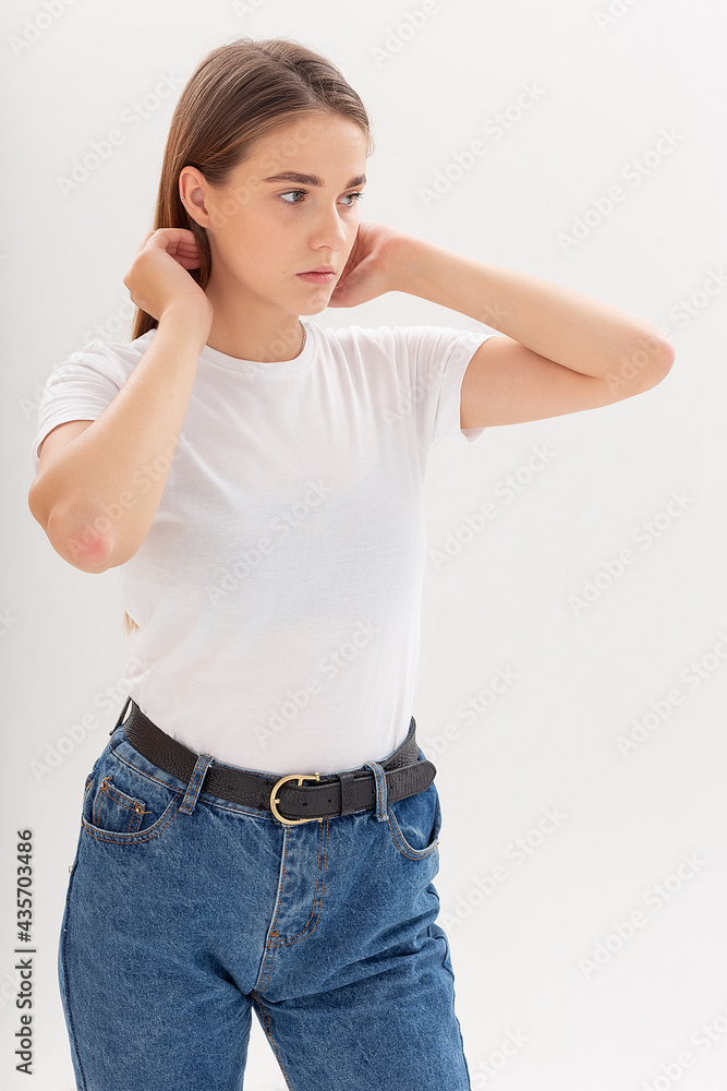 portrait of young attractive caucasian woman with long hair in t-shirt and blue jeans isolated on white studio background. skinny pretty female posing on cyclorama. model tests of beautiful lady portrait of young attractive caucasian woman with long hair in t-shirt and blue jeans isolated on white studio background. skinny pretty female posing on cyclorama. model tests of beautiful lady