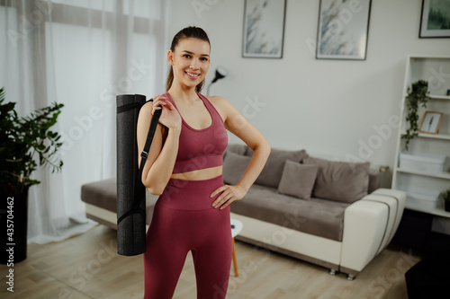 Portrait of excited yoga teacher posing with fitness mat looking at camera, happy fitness trainer. Free Download Portrait of excited yoga teacher posing with fitness mat looking at camera, happy fitness trainer. - GFXLoad