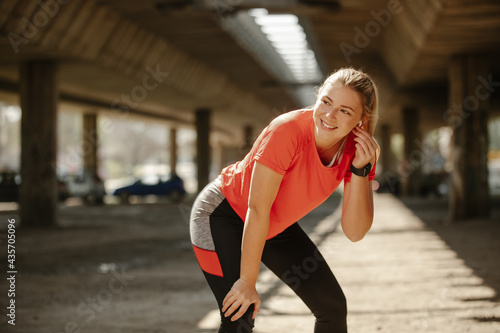 Jogging woman setting music and running route on smart phone putting earphones before morning run.