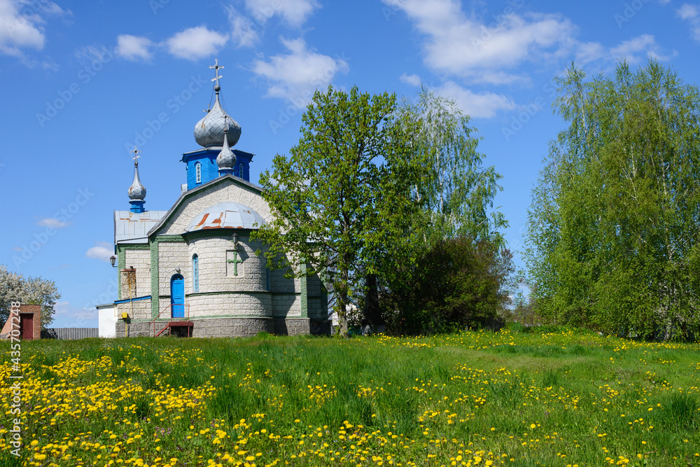 Rural church on a background of blue sky and among dandelions on a warm spring day. Travel by Ukraine. Rural church on a background of blue sky and among dandelions on a warm spring day. Travel by Ukraine.