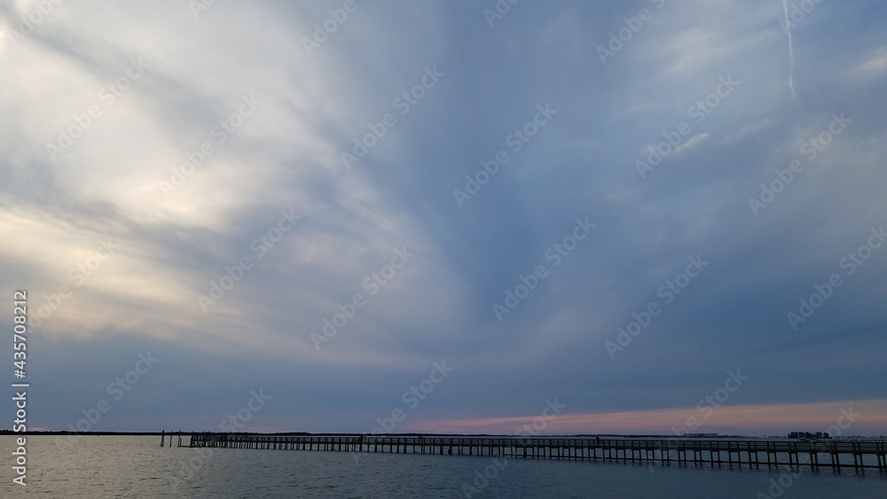 Dark swirly clouds with a pink horizon at sunset