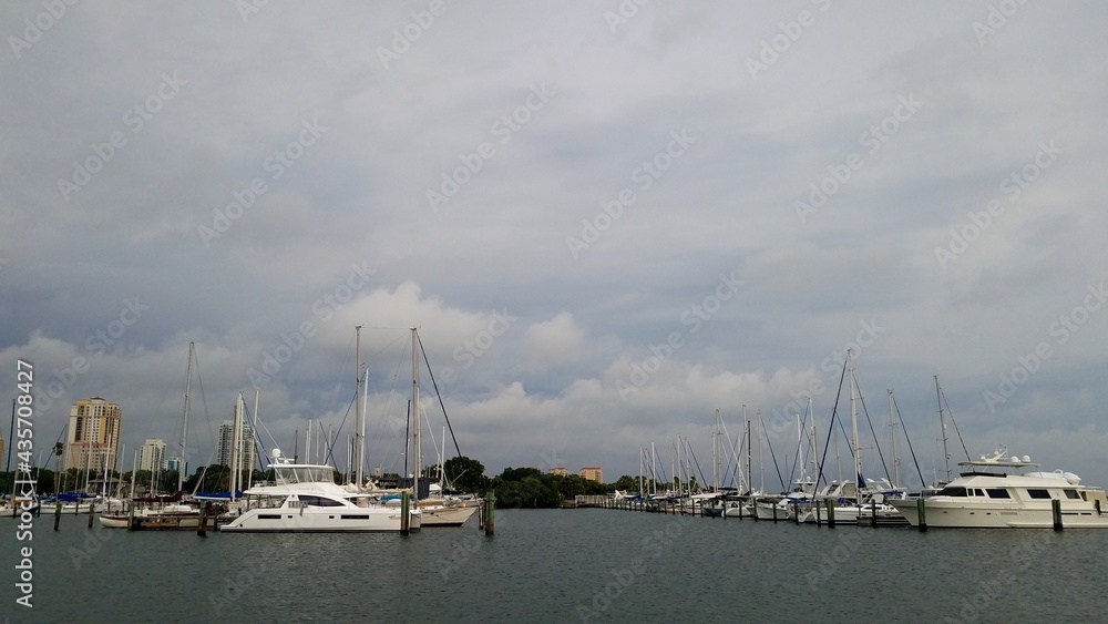 Boats docked at the marina with dark clouds