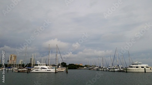 Boats docked at the marina with dark clouds