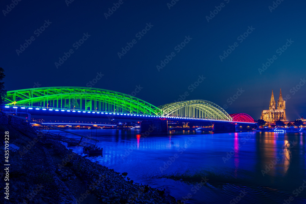 Obraz premium Panoramic view of Cologne Cathedral with Hohenzollern Bridge at the blue hour, Germany.