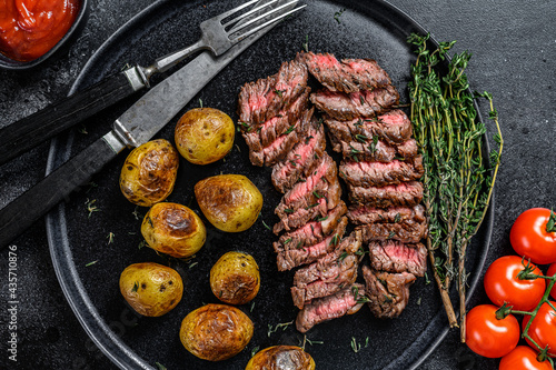 Grilled marble meat beef Steak with fried potato. Black background. Top view