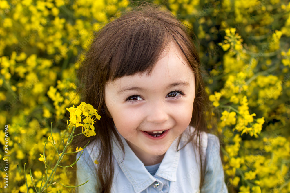 little girl in a blooming yellow rapeseed field. baby around with yellow flowers little girl in a blooming yellow rapeseed field. baby around with yellow flowers