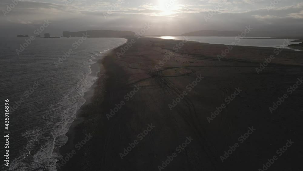 Aerial tilt up reveal along black sand beach and beautiful landscape in background, Iceland Aerial tilt up reveal along black sand beach and beautiful landscape in background, Iceland
