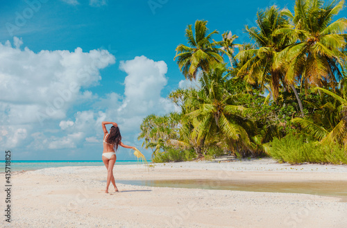 Beach vacation woman sunbathing relaxing on remote island in Rangiroa atoll, Tuamotu islands, French Polynesia. Tahiti travel dream destination bikini tourist girl relaxing walking on secluded beach. photo