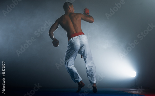 One judoka fighter man in kimono practicing in the gym © qunica.com