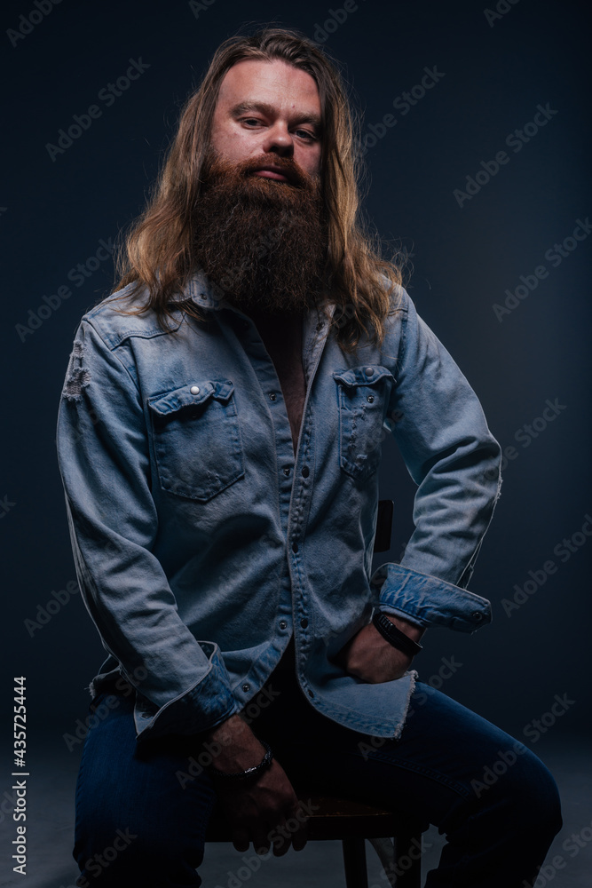 Close up portrait of handsome manly guy with beard posing in studio on a isolated background.