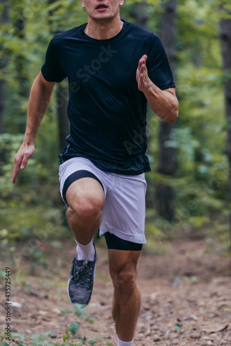 Close up picture of a handsome jogger jogging in the forest