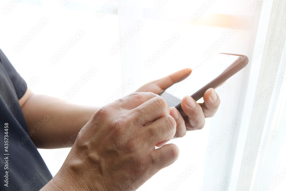 man hand holding smart phone at office
