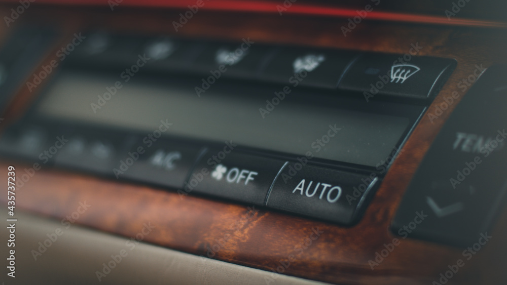Close up of car panel with the air conditioning button inside a car.