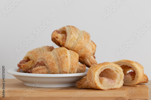 Croissants of calabreza on cutting board and white background. photo