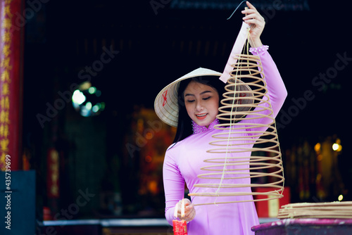 Vietnamese woman in traditional dress praying