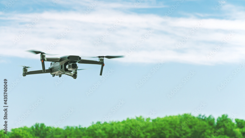 professional aerial drone flying in the blue cloudy sky in sunny summer day professional aerial drone flying in the blue cloudy sky in sunny summer day