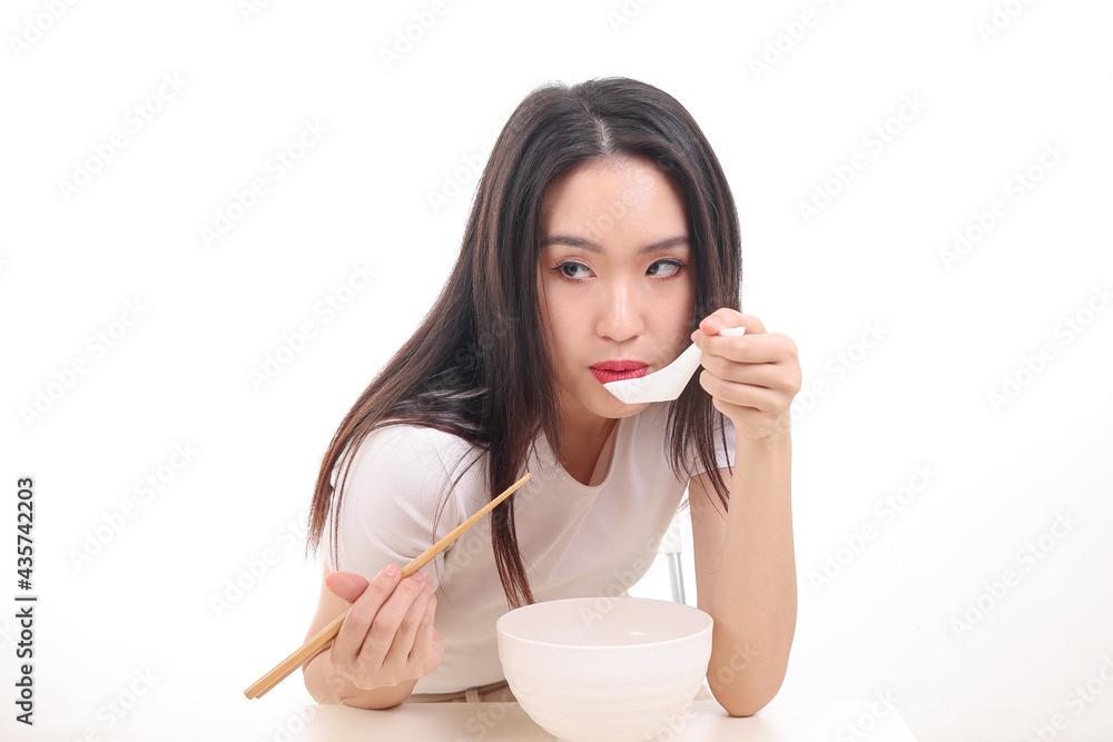 Beautiful young south east Asian woman holding chinese empty chopstick soup spoon bowl utensil pretend acting posing see eat taste feed offer satisfaction yummy white background happy Beautiful young south east Asian woman holding chinese empty chopstick soup spoon bowl utensil pretend acting posing see eat taste feed offer satisfaction yummy white background happy