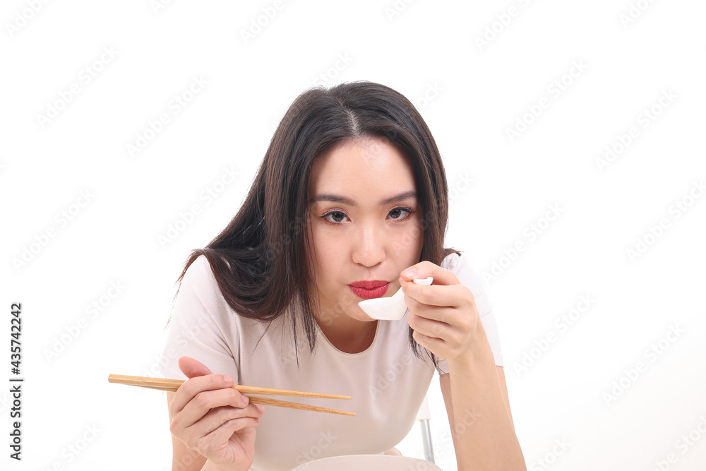 Beautiful young south east Asian woman holding chinese empty chopstick soup spoon bowl utensil pretend acting posing see eat taste feed offer satisfaction yummy white background happy blow cool Beautiful young south east Asian woman holding chinese empty chopstick soup spoon bowl utensil pretend acting posing see eat taste feed offer satisfaction yummy white background happy blow cool
