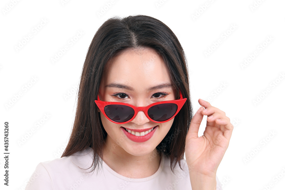 Beautiful young south east Asian woman peaking over wearing red frame dark sunglass pose fashion style white background smile happy Beautiful young south east Asian woman peaking over wearing red frame dark sunglass pose fashion style white background smile happy