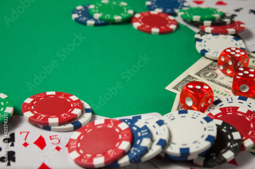 Classic playing cards, chips, red dice and dollars on green background. Gambling and casino concept.
