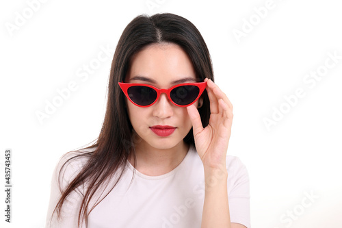 Beautiful young south east Asian woman wearing red frame dark sunglass pose fashion style white background