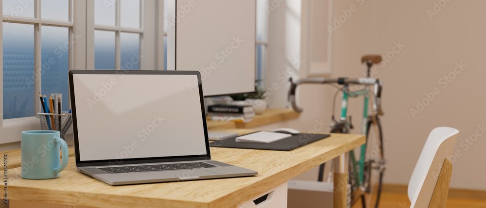Laptop with mock-up screen on wooden worktable beside the window in the room with bicycle, 3D rendering Laptop with mock-up screen on wooden worktable beside the window in the room with bicycle, 3D rendering