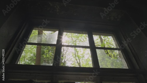Sunlight through broken glass window in dark room in abandoned building or dungeon.
