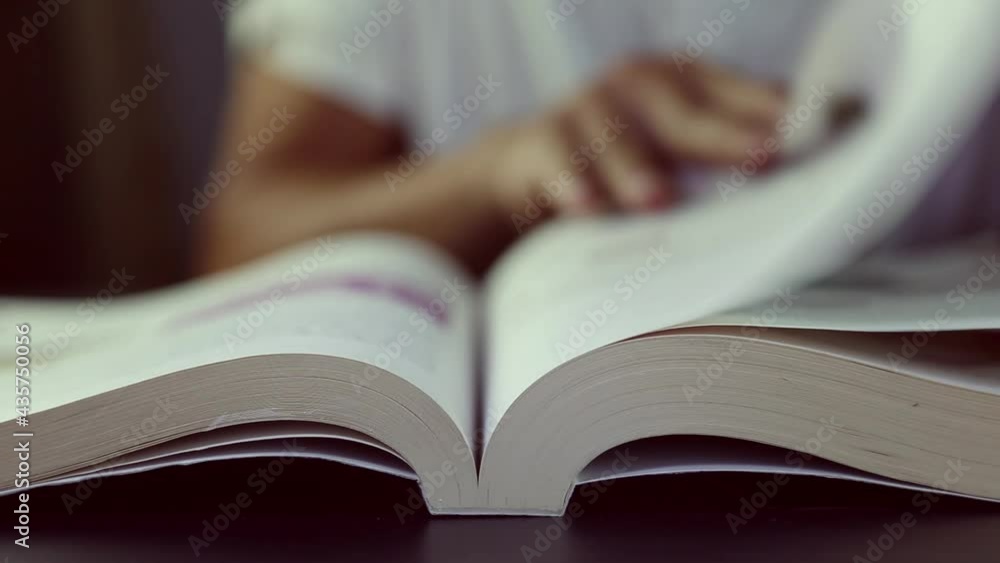 Asian man hand reading a interesting book while staying at home. He turning page of learning English book . Adult man using his finger pointing on a book Asian man hand reading a interesting book while staying at home. He turning page of learning English book . Adult man using his finger pointing on a book