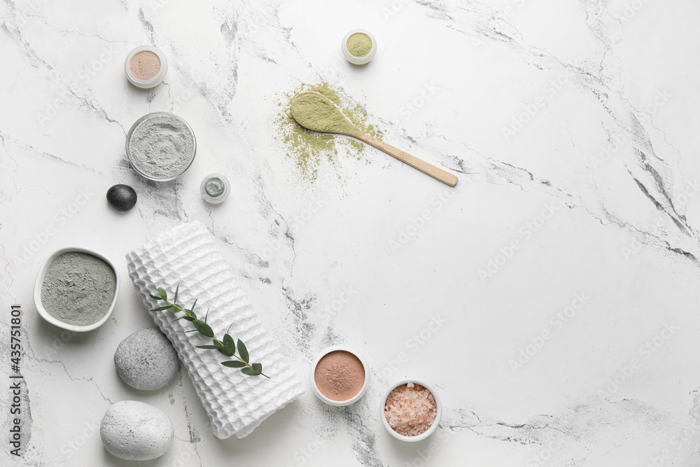 Composition with cosmetic clay, towel and spa stones on light background Composition with cosmetic clay, towel and spa stones on light background