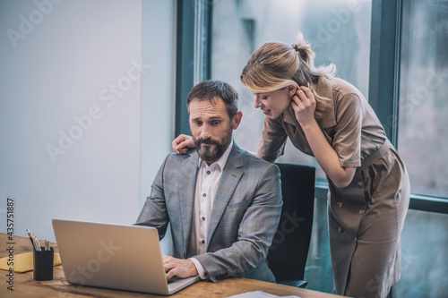 Scared boss and leaning woman talking smiling photo